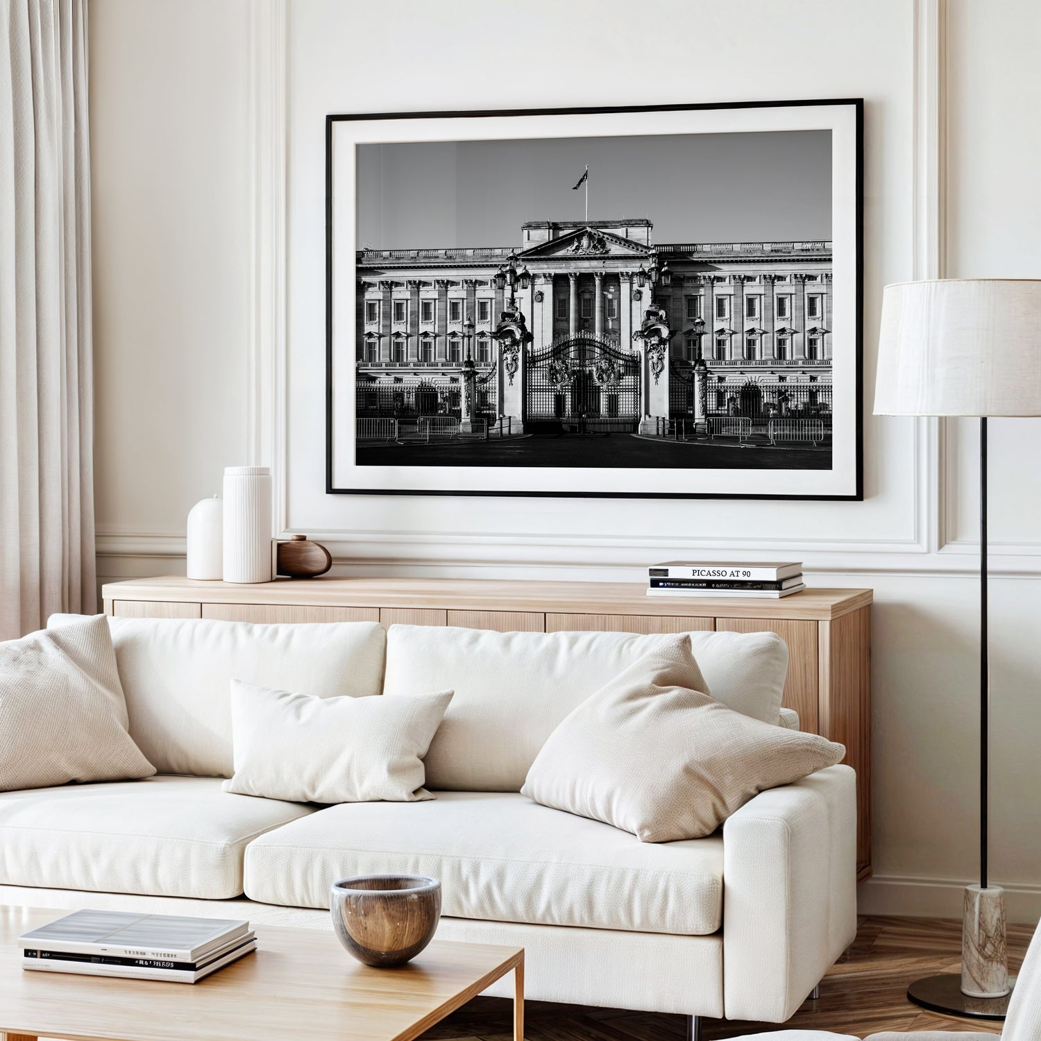 Black and white photograph of Buckingham Palace with decorative gates and clear sky, captured in London.