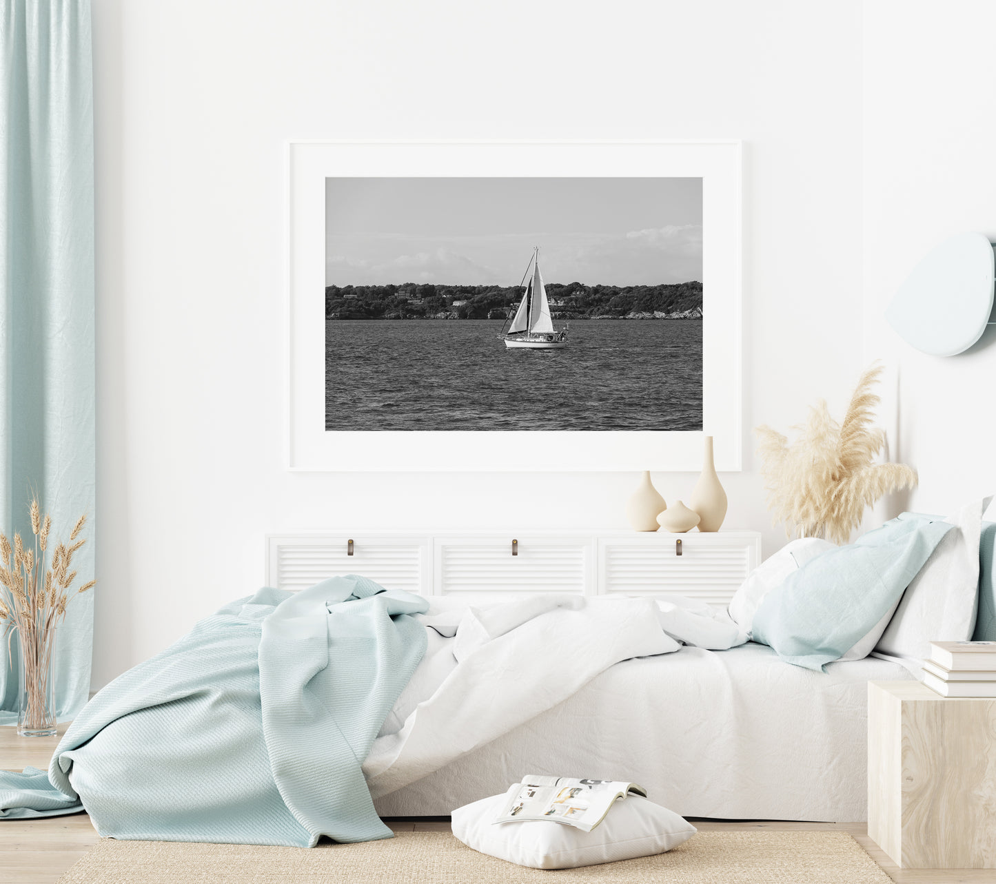 Horizontal black and white sailboat photo taken in Newport, Rhode Island, featuring a single sailboat on open water with a calm shoreline in the background. Ideal for coastal wall decor and lake house art.