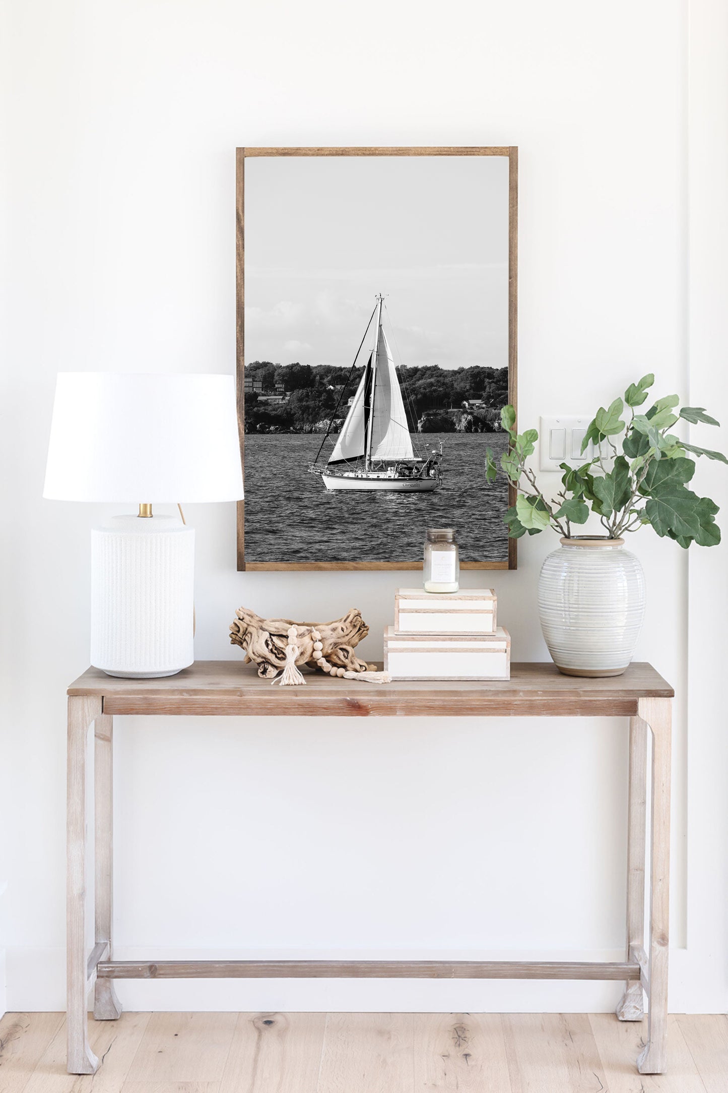 Black and white photo of a sailboat sailing in Newport, Rhode Island, with calm ocean water and soft horizon in the background. Coastal nautical wall art.