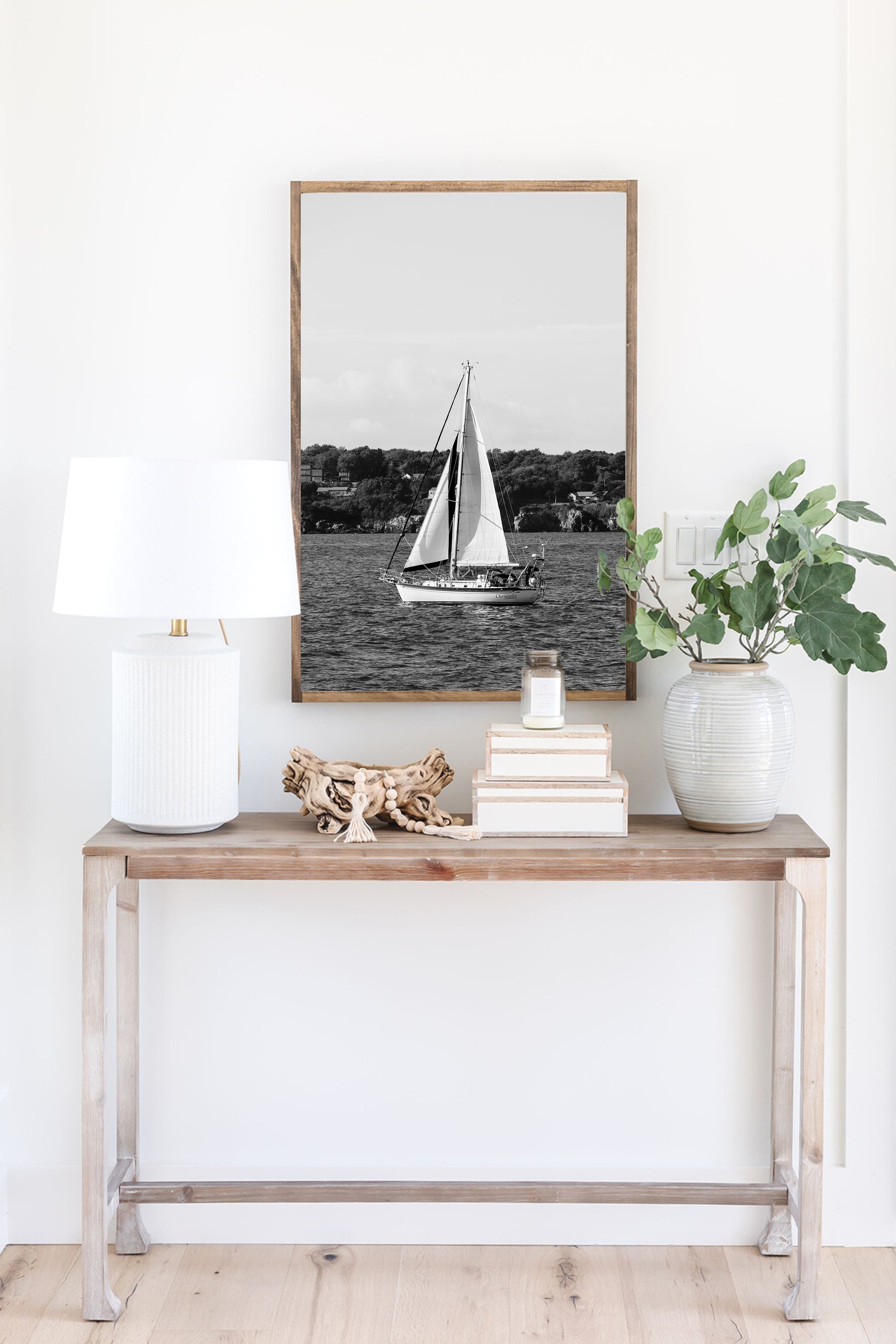 Black and white photo of a sailboat sailing in Newport, Rhode Island, with calm ocean water and soft horizon in the background. Coastal nautical wall art.