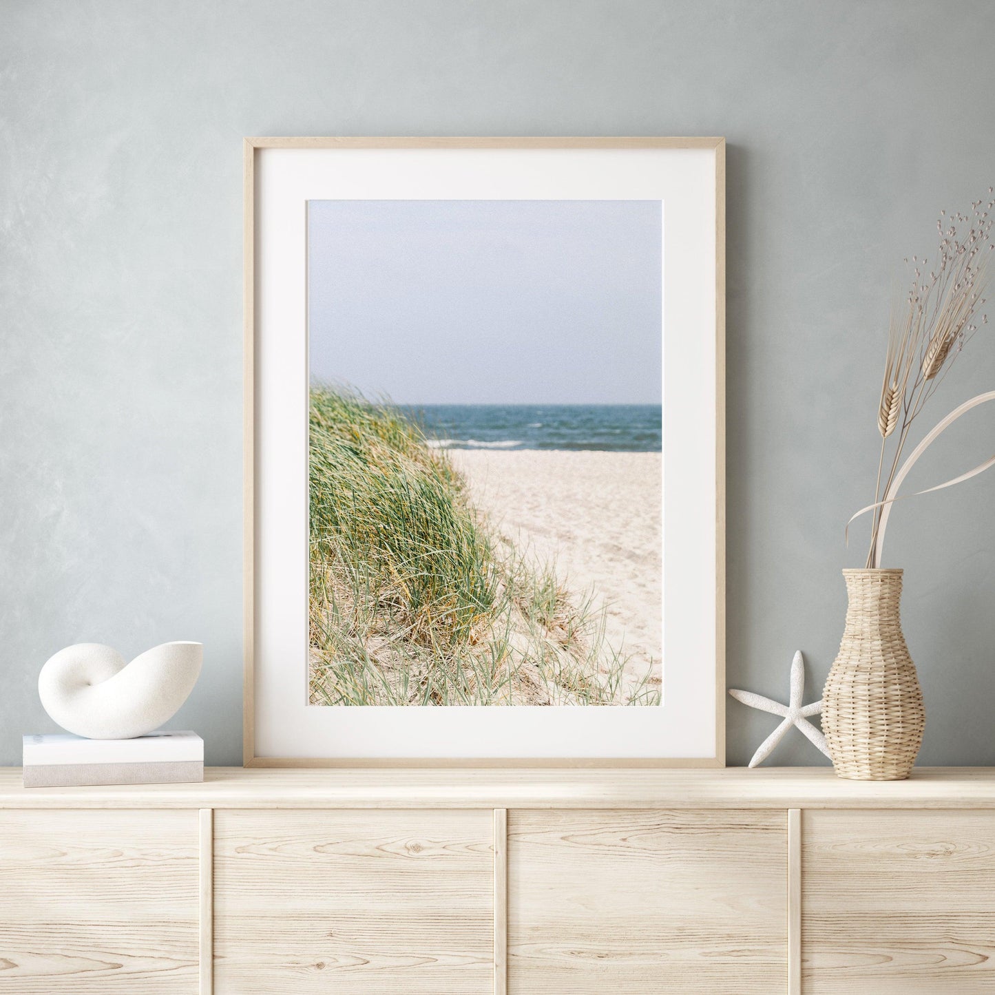 Neutral-toned beach photography of sand dunes and beach grass under a pale sky, evoking a coastal New England feel with a Nantucket aesthetic