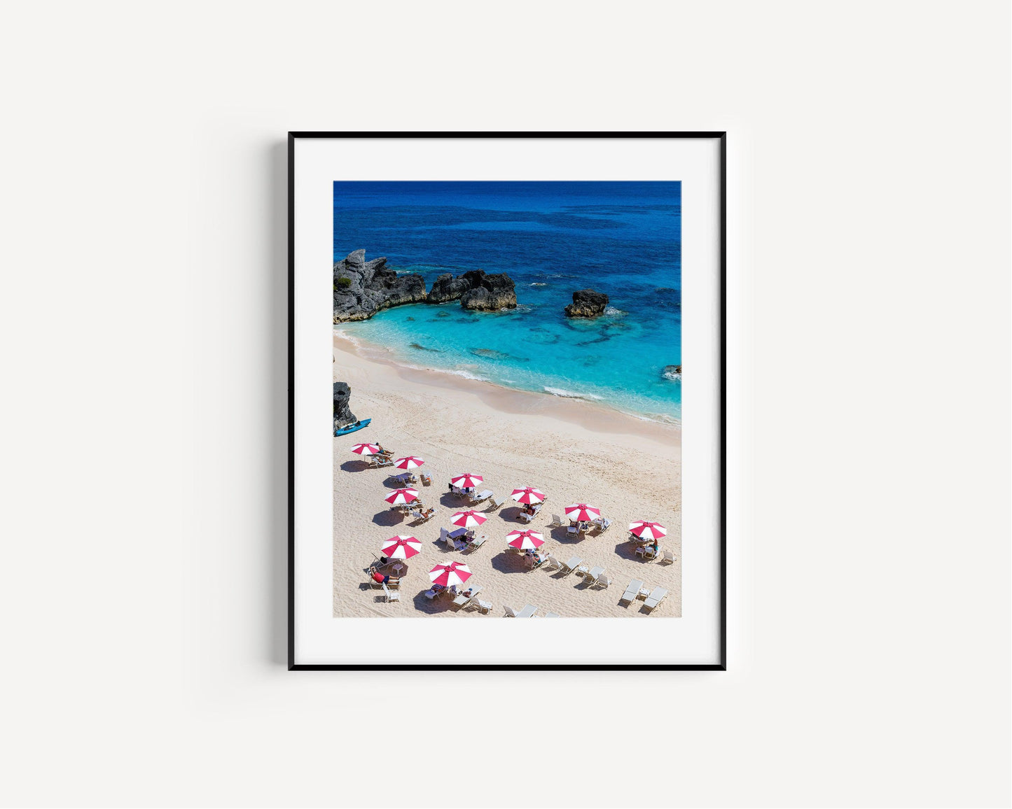 Pink and white beach umbrellas by the ocean.