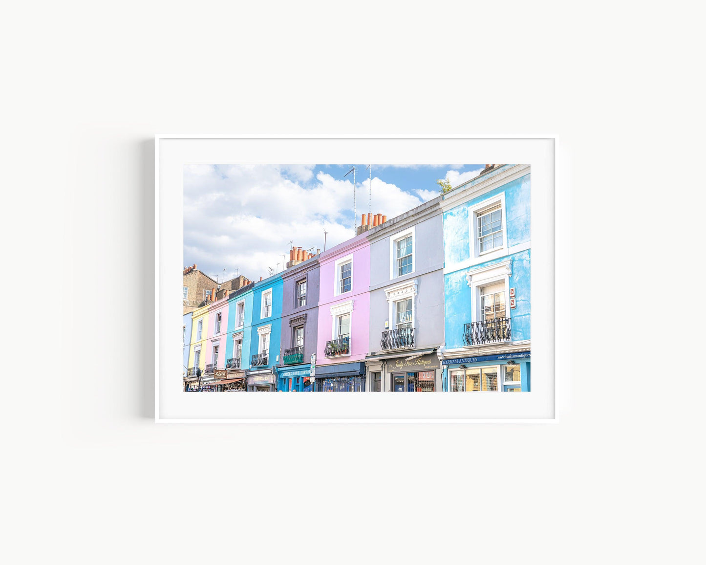 Colorful pastel buildings on Portobello Road in Notting Hill, London under a partly cloudy sky