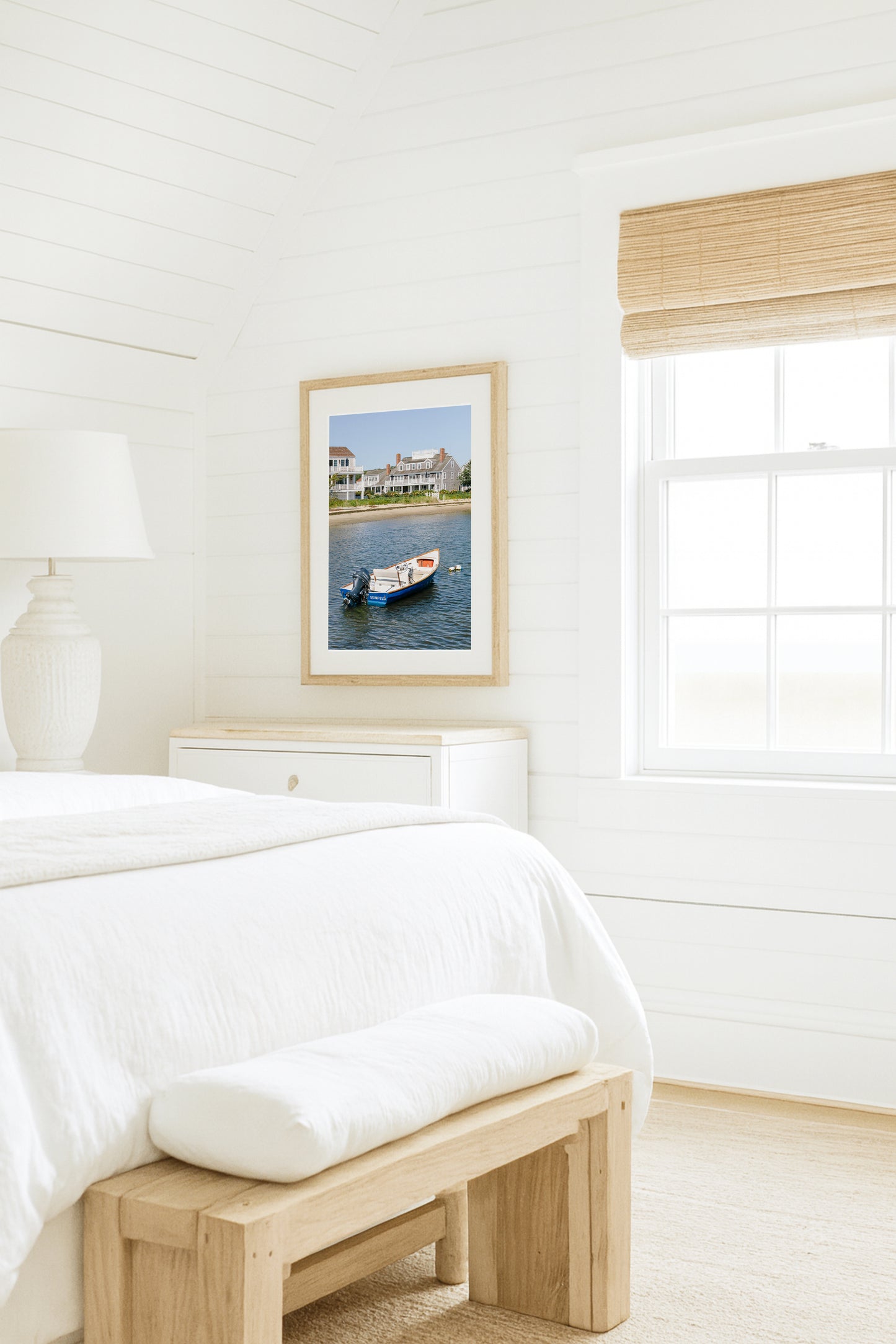 Vertical beach photography print of a small blue boat floating in Nantucket harbor, with Cape Cod-style houses and sandy shoreline in the background — perfect for nautical home decor and coastal wall art.