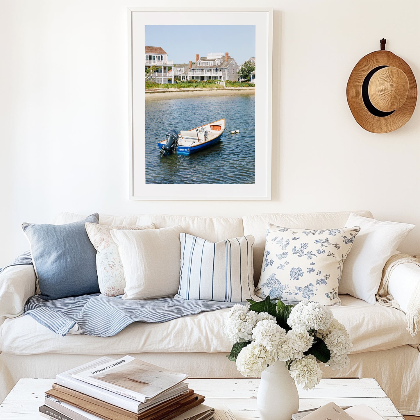 Vertical beach photography print of a small blue boat floating in Nantucket harbor, with Cape Cod-style houses and sandy shoreline in the background — perfect for nautical home decor and coastal wall art.