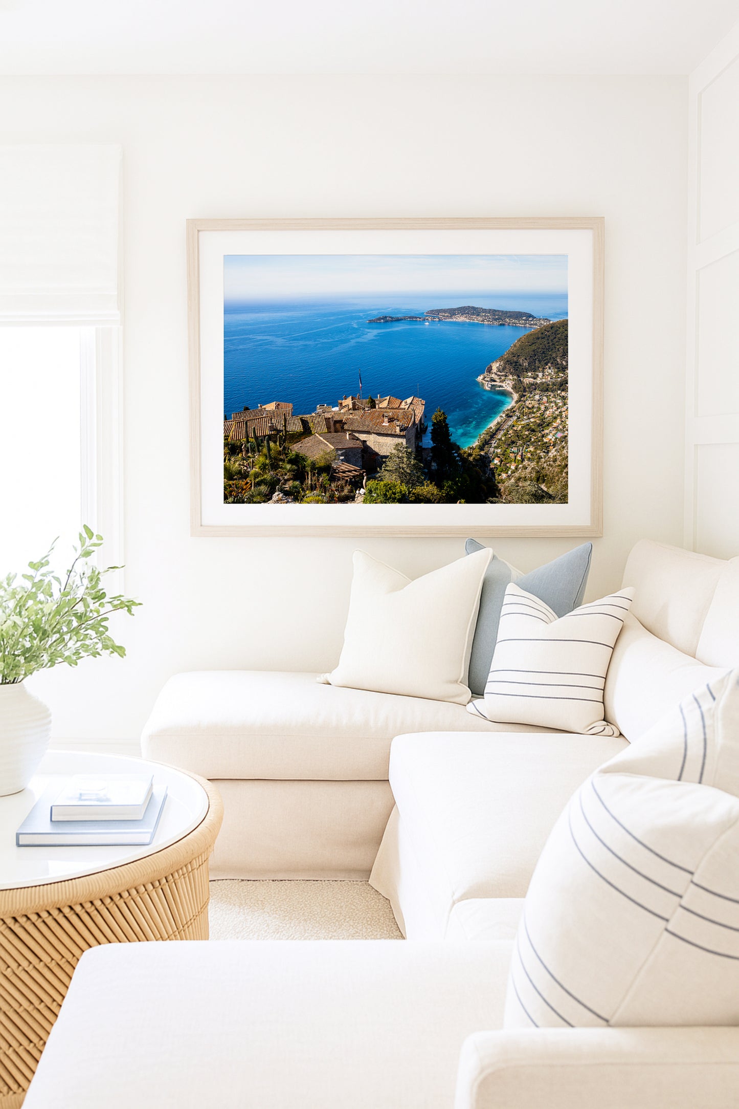 Village of Èze, France print featuring rooftops and the Mediterranean Sea styled in a neutral living room