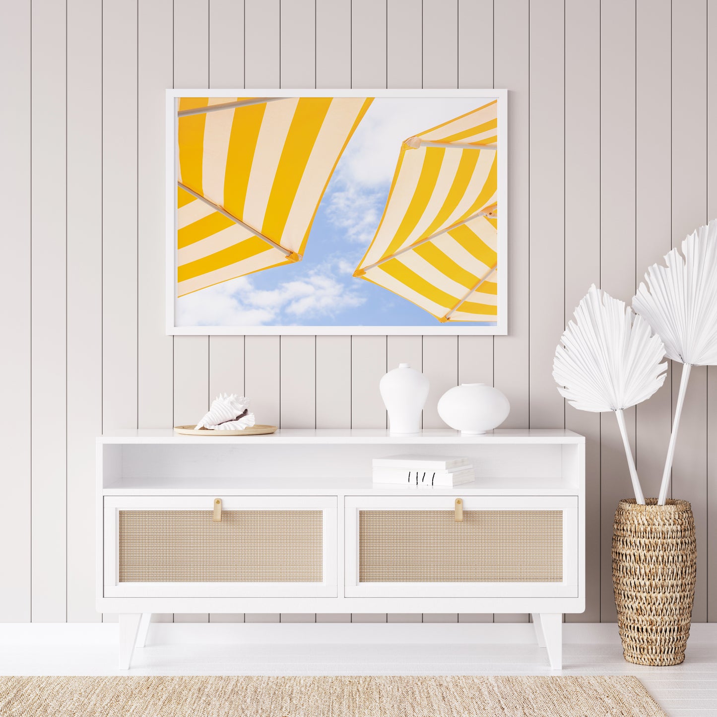 Yellow and white striped beach umbrellas set against a bright blue sky with scattered clouds; minimalist beach photography evoking a sunny Amalfi Coast vibe.