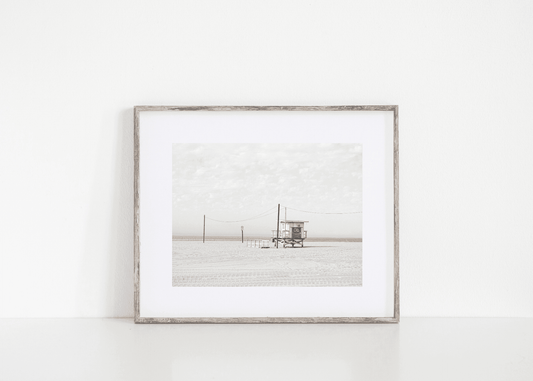 Black and white beach photo of lifeguard tower on California sand – minimalist coastal wall art