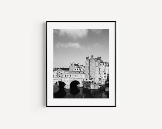 Black and white photo of Pulteney Bridge in Bath, England, with river reflection and historic buildings