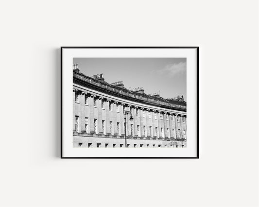 Black and white photo of Royal Crescent in Bath, England, showing curved Georgian facade with columns and chimney stacks