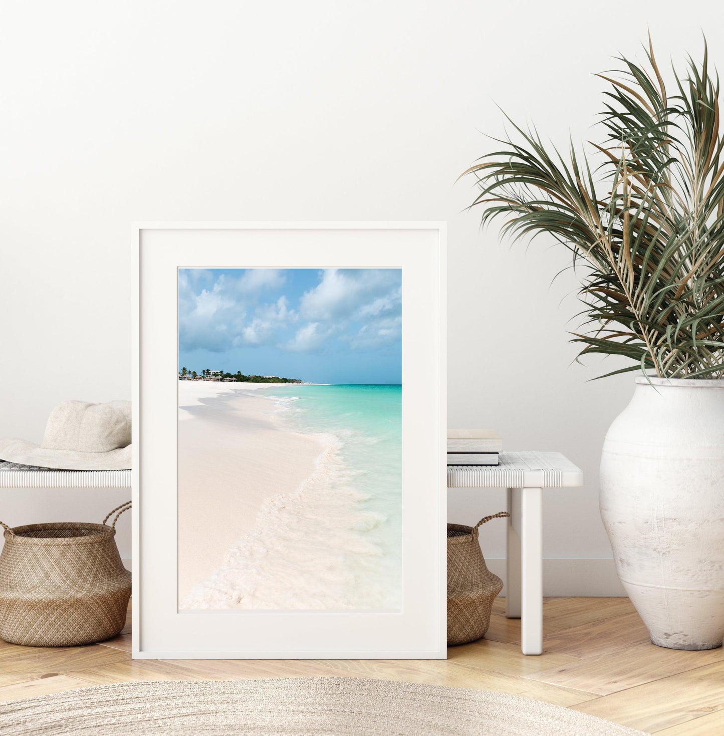 Color fine art photograph of Eagle Beach in Aruba — powder white sand, turquoise Caribbean water with a gentle wave at the shoreline, and palapa huts visible in the distance