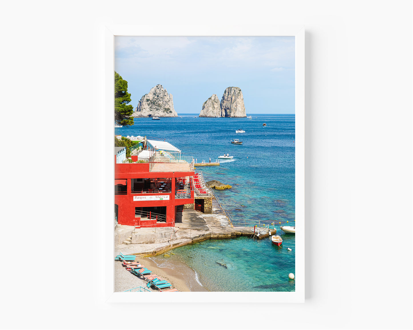 The red Bagni di Maria beach club at Marina Piccola with turquoise water and the iconic Faraglioni rock stacks rising from the sea, Capri, Italy