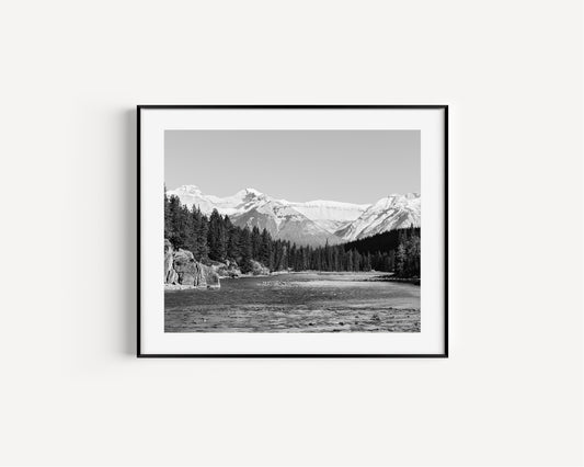 Black and white nature photography print of the Bow River in Banff National Park, with pine trees and Canadian Rockies in Alberta Canada.