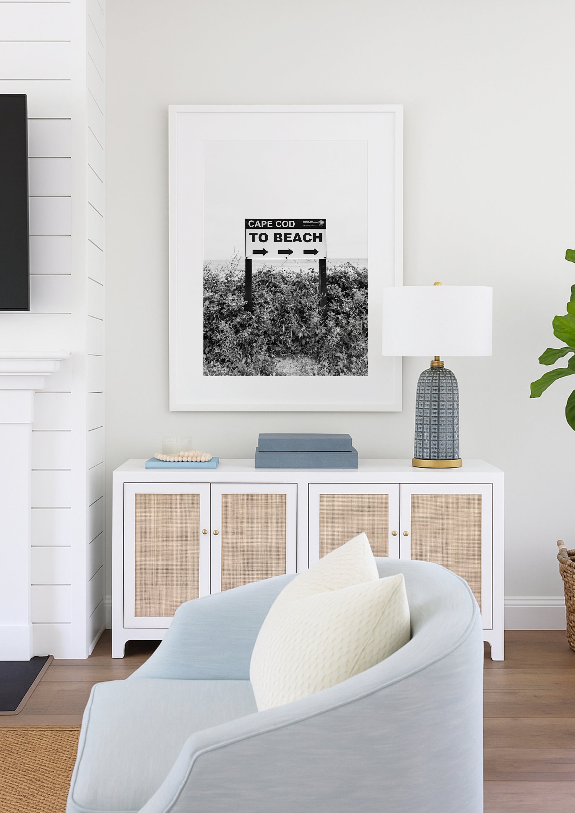 Black and white photography print of a vintage-style sign reading 'Cape Cod Beach This Way' with an arrow, set against a clear sky.