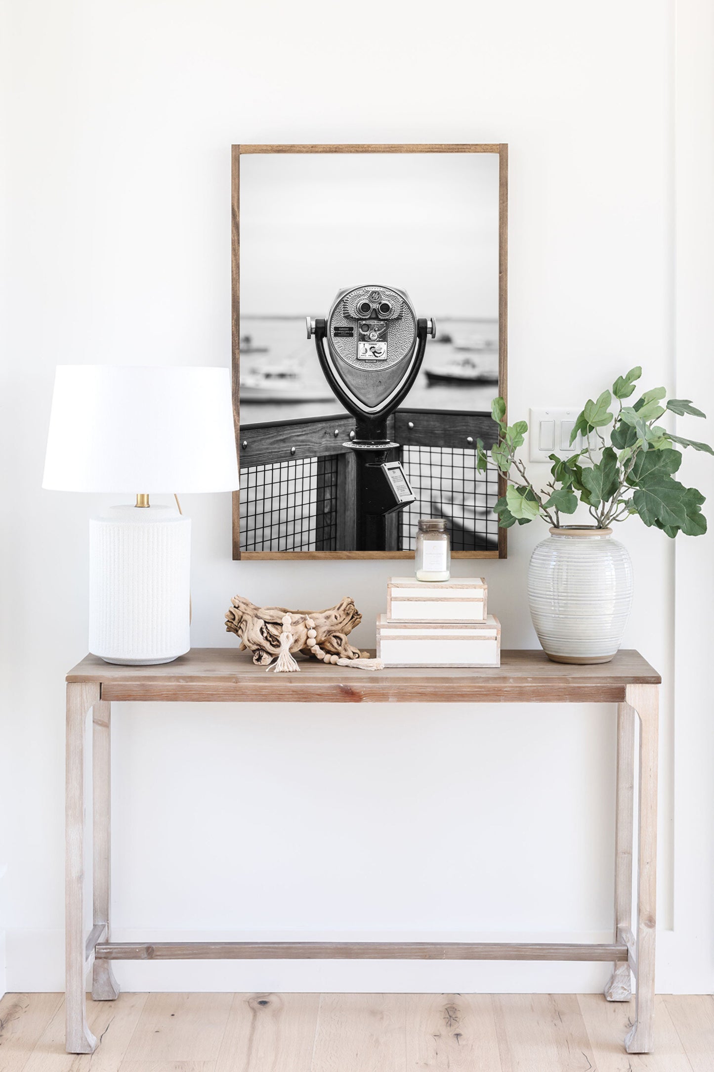 Black and white fine art photograph of a coin-operated viewfinder binoculars on Chatham Pier, Cape Cod — boats soft in the harbor background, wooden pier railing in foreground