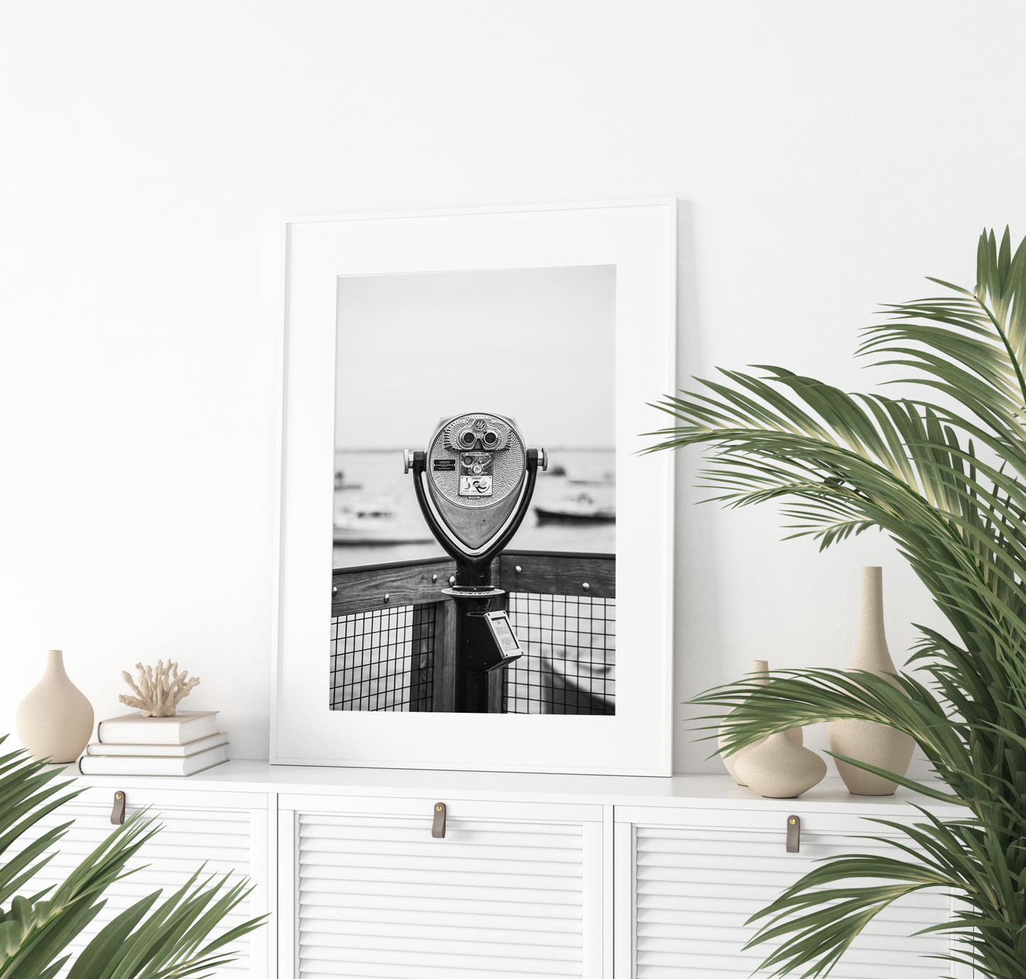 Black and white fine art photograph of a coin-operated viewfinder binoculars on Chatham Pier, Cape Cod — boats soft in the harbor background, wooden pier railing in foreground