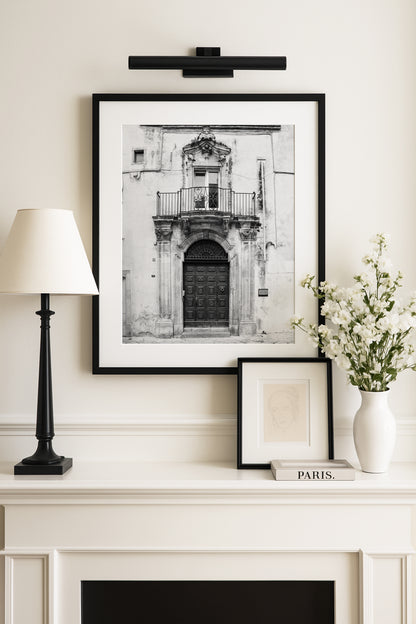 Black and white photograph of a stone Italian doorway in Puglia with arched detail and weathered texture