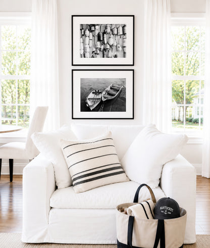 Black and white fine art photograph of two wooden row boats tied together on dark rippling water — overhead angle, oars resting inside, nautical coastal wall art