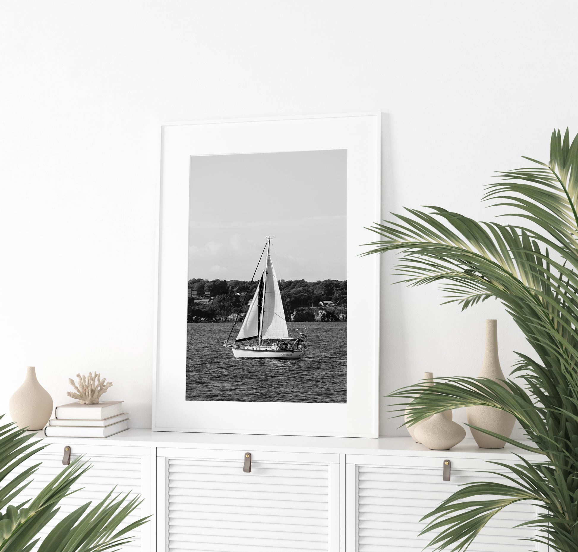Black and white photo of a sailboat sailing in Newport, Rhode Island, with calm ocean water and soft horizon in the background. Coastal nautical wall art.