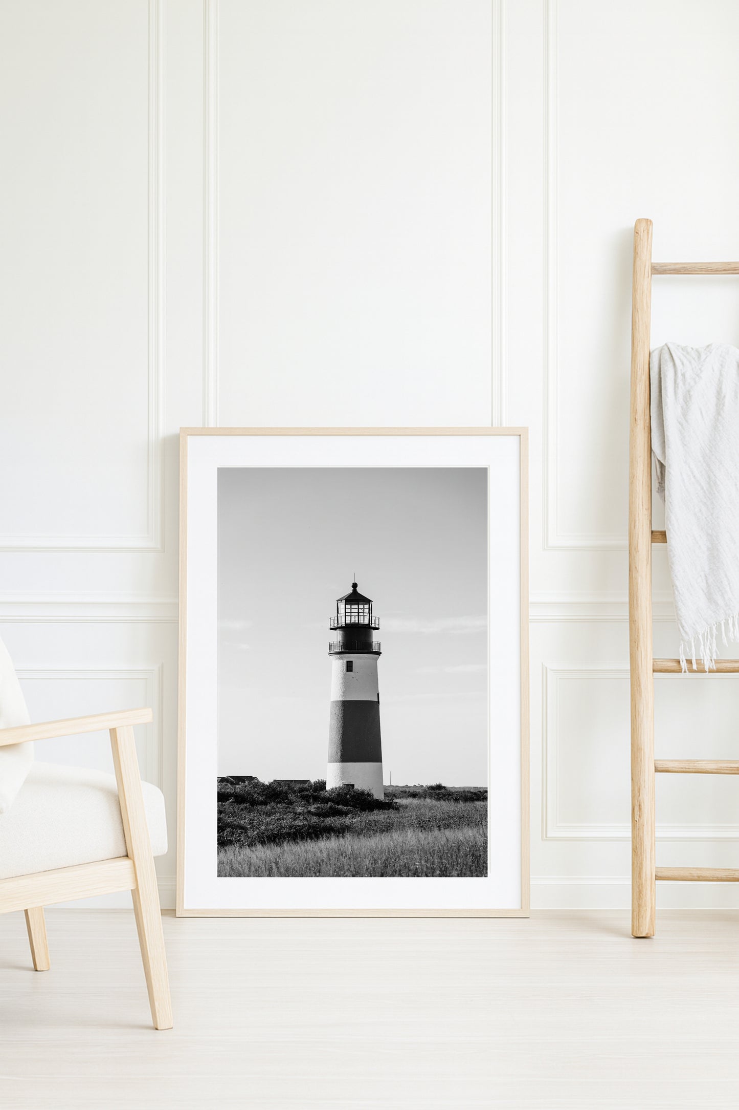 Black and white fine art photograph of Sankaty Head Lighthouse on Nantucket Island — banded tower rising above wild moor grass against an open sky in Siasconset