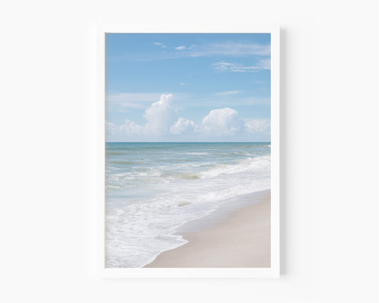 Vertical framed print featuring soft ocean waves and blue sky, photographed at Kure Beach, North Carolina. Ideal for coastal wall decor and minimalist beach interiors.