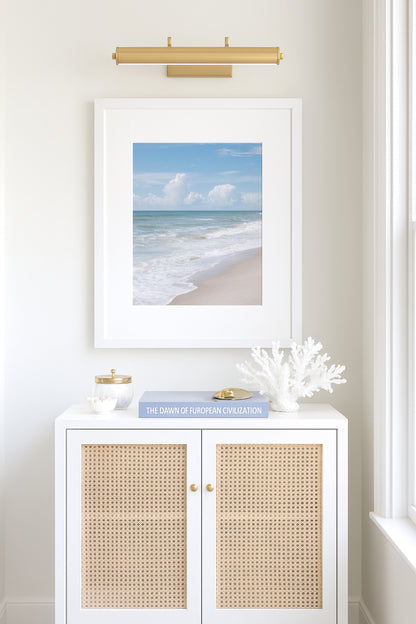 Vertical framed print featuring soft ocean waves and blue sky, photographed at Kure Beach, North Carolina. Ideal for coastal wall decor and minimalist beach interiors.