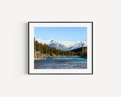 Color nature photography print of the Bow River in Banff National Park, Alberta Canada, with pine trees and snow-covered mountains.