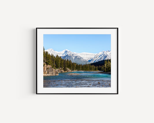 Color nature photography print of the Bow River in Banff National Park, Alberta Canada, with pine trees and snow-covered mountains.