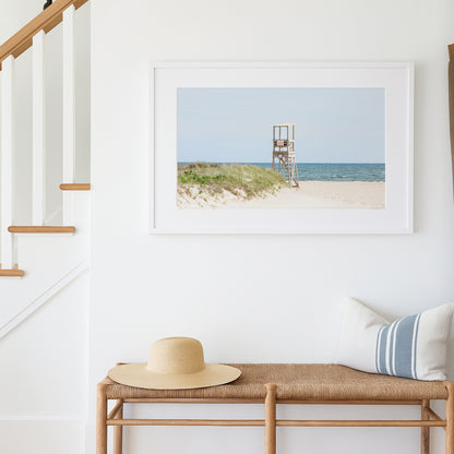 Color fine art photograph of an empty lifeguard stand at Bank Street Beach on Cape Cod — rolling sand dunes, sea grass, and the open Atlantic under a pale summer sky