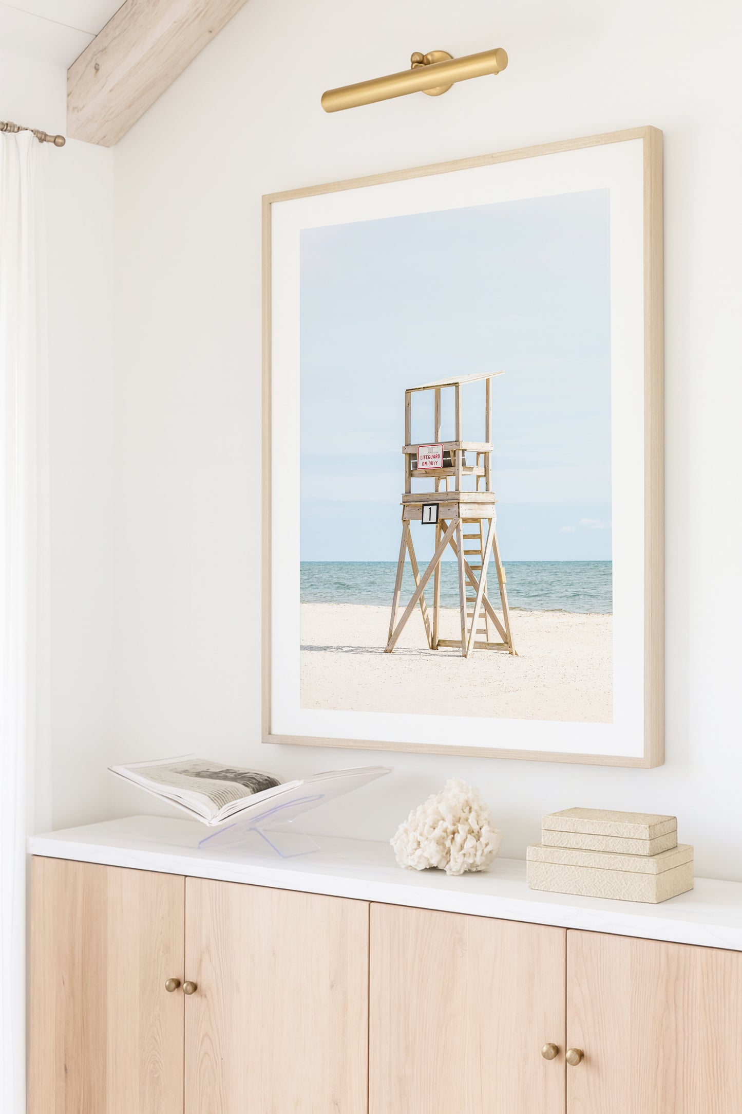 Color fine art photograph of an empty wooden lifeguard tower at Bank Street Beach in Harwich, Cape Cod — white sand and blue-green Atlantic in the background