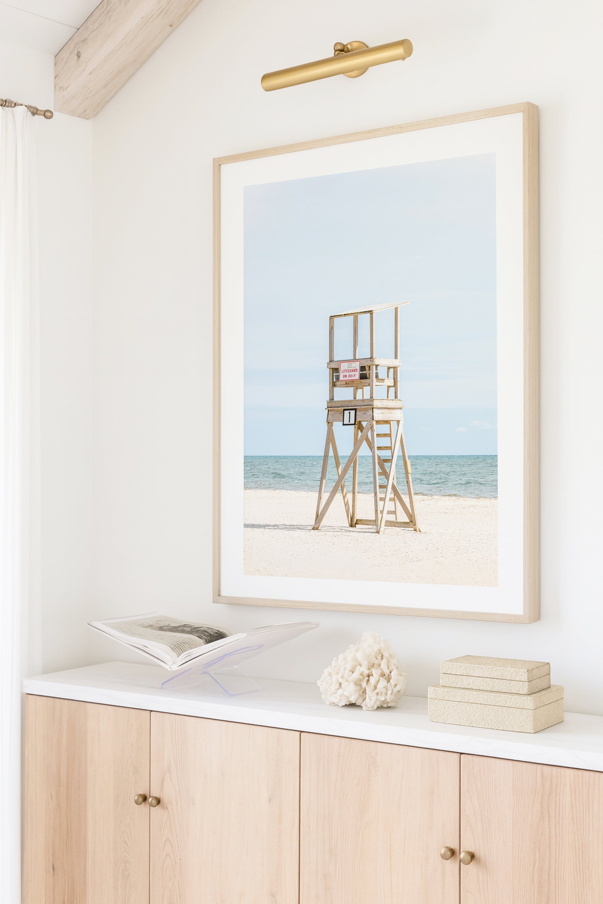 Color fine art photograph of an empty wooden lifeguard tower at Bank Street Beach in Harwich, Cape Cod — white sand and blue-green Atlantic in the background
