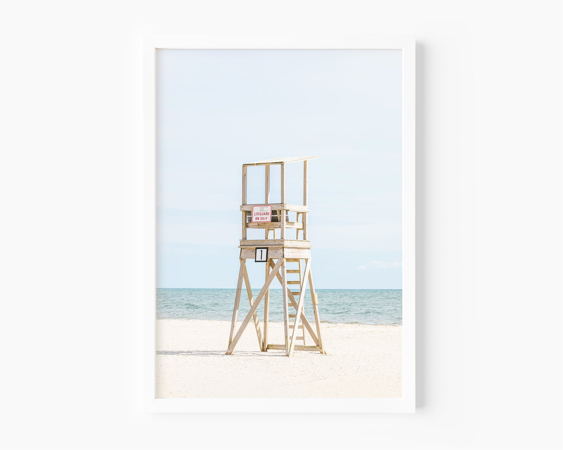 Color fine art photograph of an empty wooden lifeguard tower at Bank Street Beach in Harwich, Cape Cod — white sand and blue-green Atlantic in the background