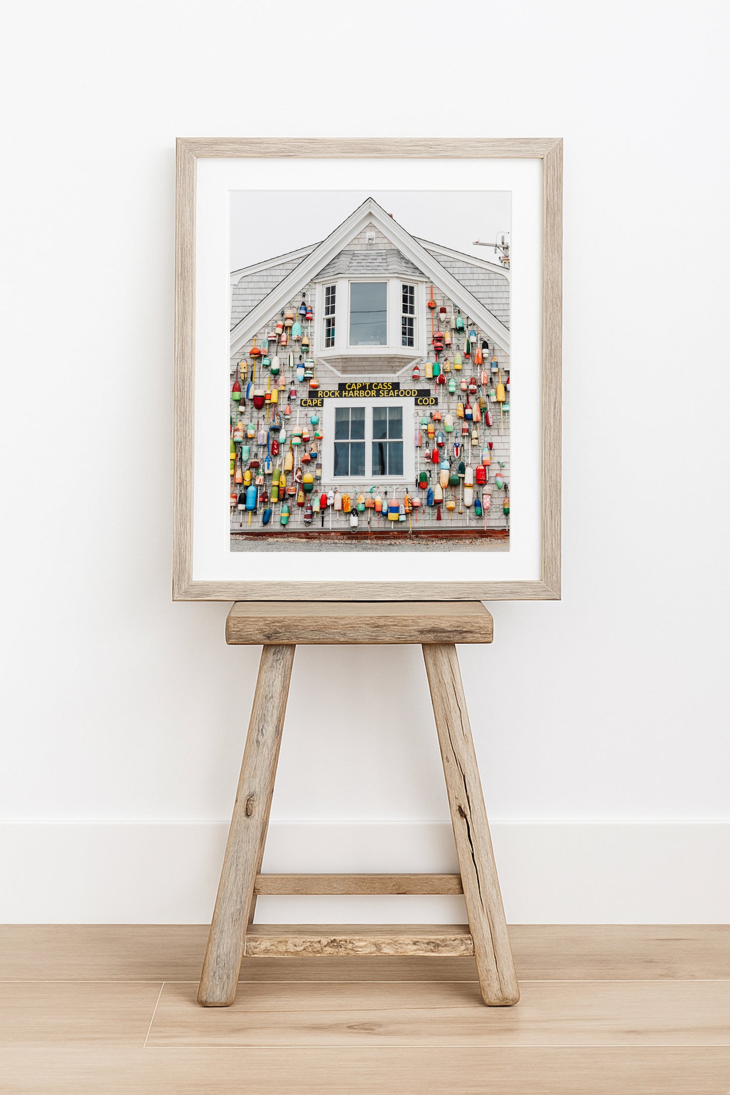 Photograph of a Cape Cod seafood shack covered in colorful fishing buoys, perfect for coastal wall decor and beach cottage interiors