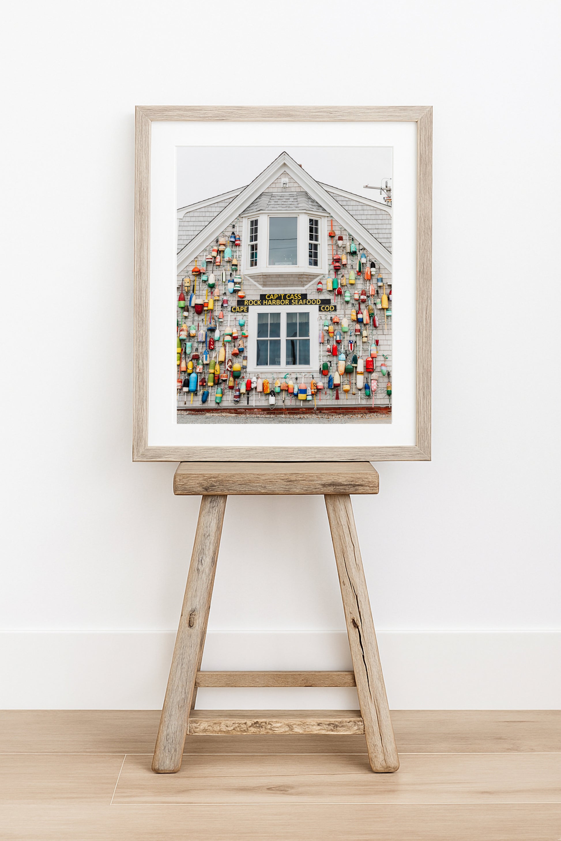 Photograph of a Cape Cod seafood shack covered in colorful fishing buoys, perfect for coastal wall decor and beach cottage interiors