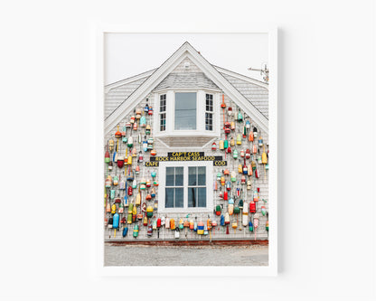 Photograph of a Cape Cod seafood shack covered in colorful fishing buoys, perfect for coastal wall decor and beach cottage interiors