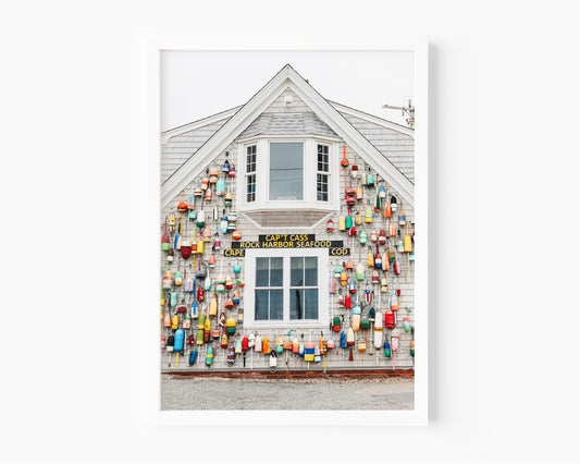Photograph of a Cape Cod seafood shack covered in colorful fishing buoys, perfect for coastal wall decor and beach cottage interiors