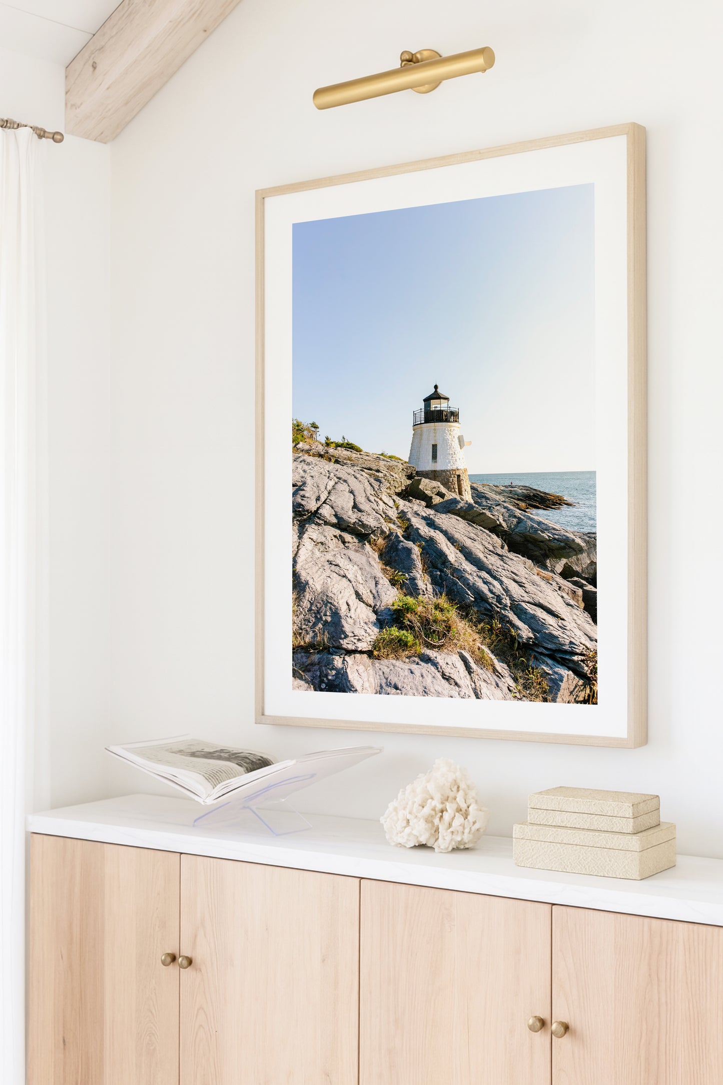 Castle Hill Lighthouse perched on rocky Rhode Island coastline under a clear sky, captured in golden hour light – Newport RI photo print for beach and coastal decor.