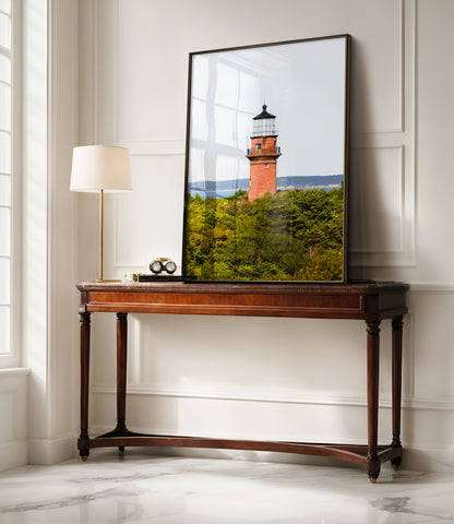 Lighthouse photo showing the red brick Gay Head Lighthouse above lush greenery in Aquinnah, Mass, with the Martha’s Vineyard coastline in the background.