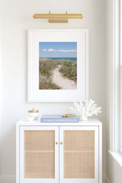 Color fine art photograph of a sandy beach path through dune grass on Martha’s Vineyard, blue-green ocean visible on the horizon under a clear blue summer sky with white clouds