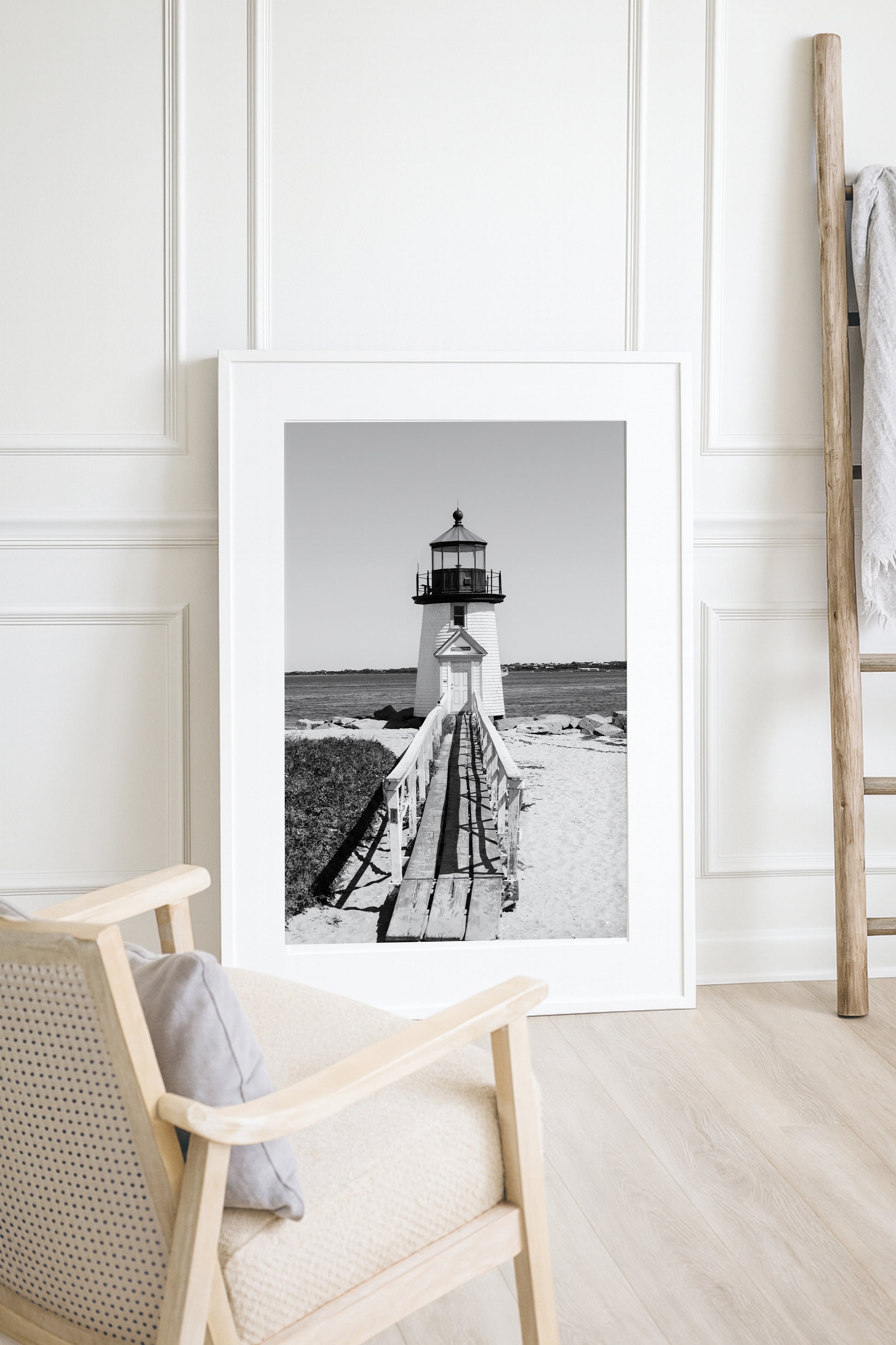 Black and white fine art photograph of Brant Point Lighthouse on Nantucket Island — wooden boardwalk leading to the white lighthouse tower with Nantucket Harbor in the background
