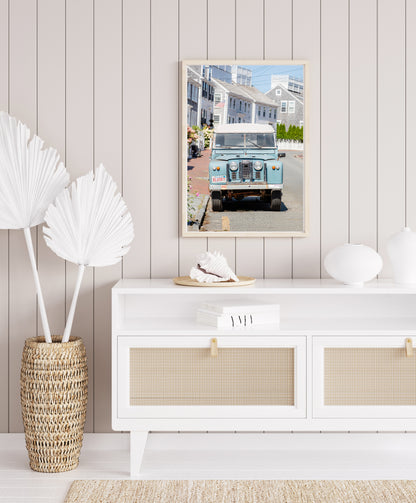 Color fine art photograph of a vintage powder blue Land Rover Series parked on a cobblestone street in Nantucket — Massachusetts vanity plate BLUSKY, grey shingle cottages and hydrangeas in the background