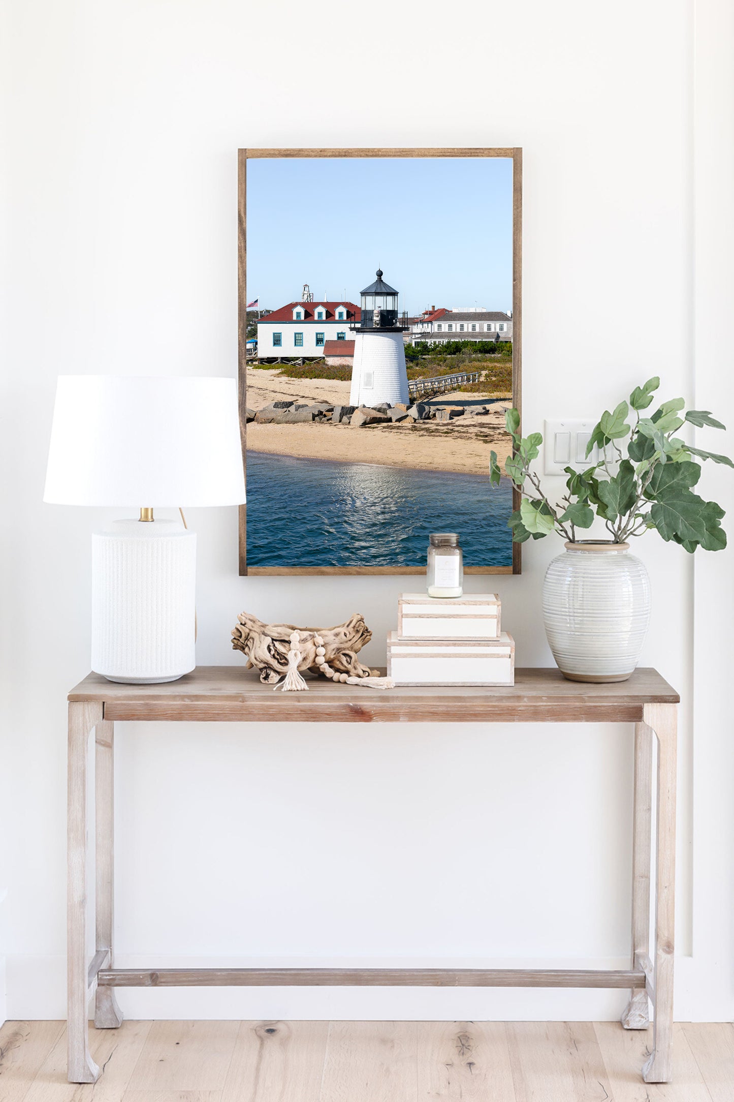 Brant Point Lighthouse print in Nantucket, featuring a white tower, rocky shoreline, and blue sky—ideal for nautical and coastal wall decor.