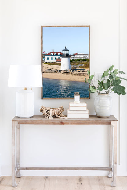 Brant Point Lighthouse print in Nantucket, featuring a white tower, rocky shoreline, and blue sky—ideal for nautical and coastal wall decor.