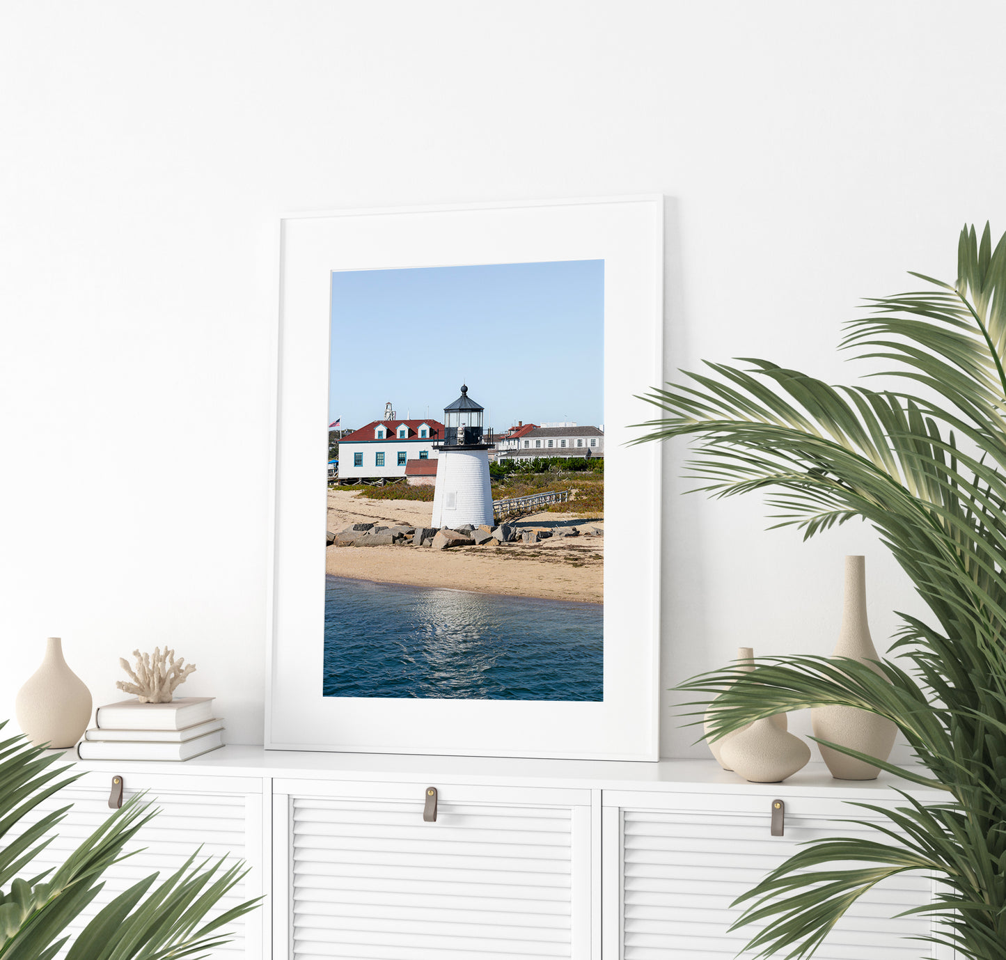 Brant Point Lighthouse print in Nantucket, featuring a white tower, rocky shoreline, and blue sky—ideal for nautical and coastal wall decor.
