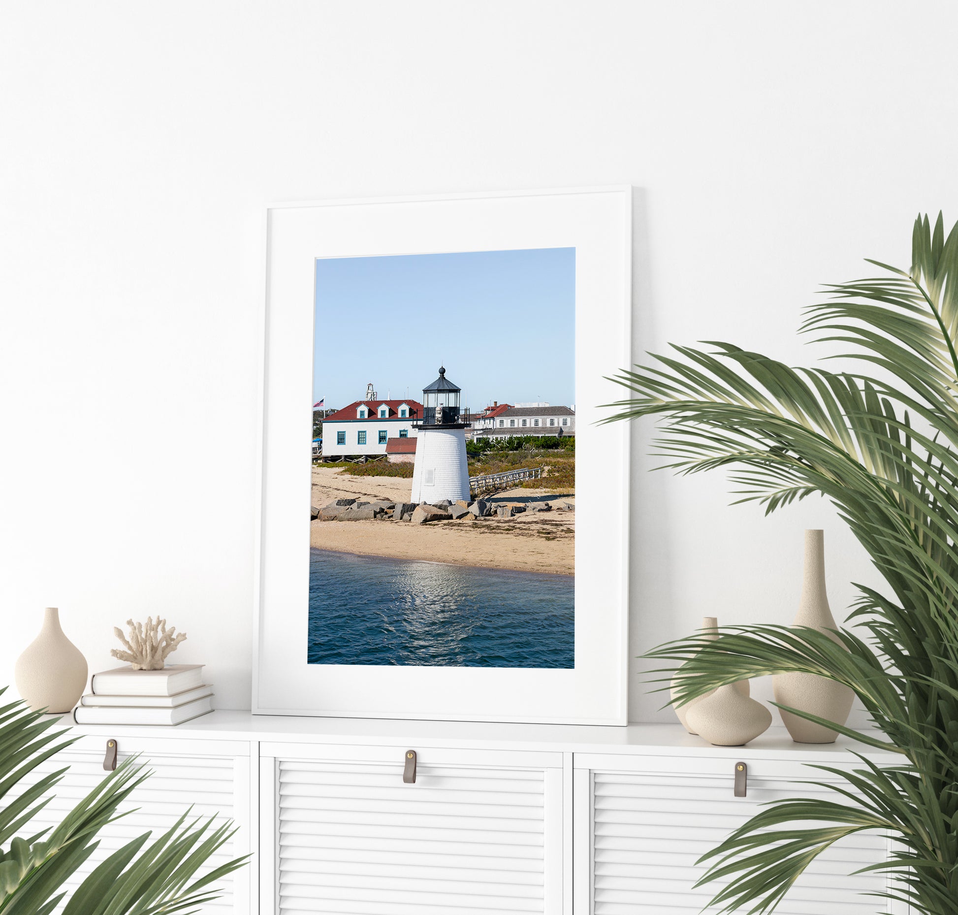 Brant Point Lighthouse print in Nantucket, featuring a white tower, rocky shoreline, and blue sky—ideal for nautical and coastal wall decor.