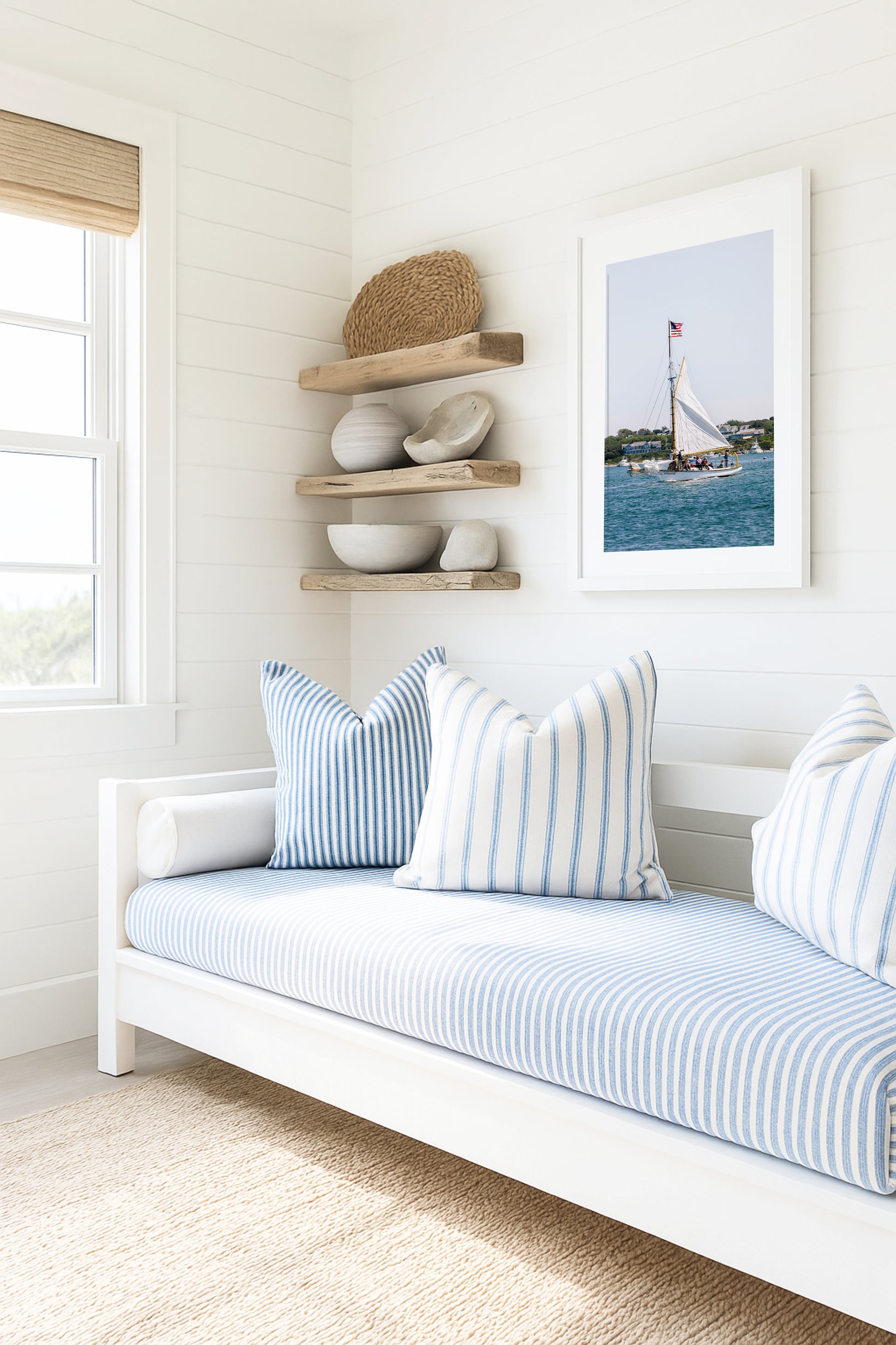 Sailboat cruising in Nantucket Harbor with white sails raised and an American flag flying, photographed on a clear summer day along the New England coastline.