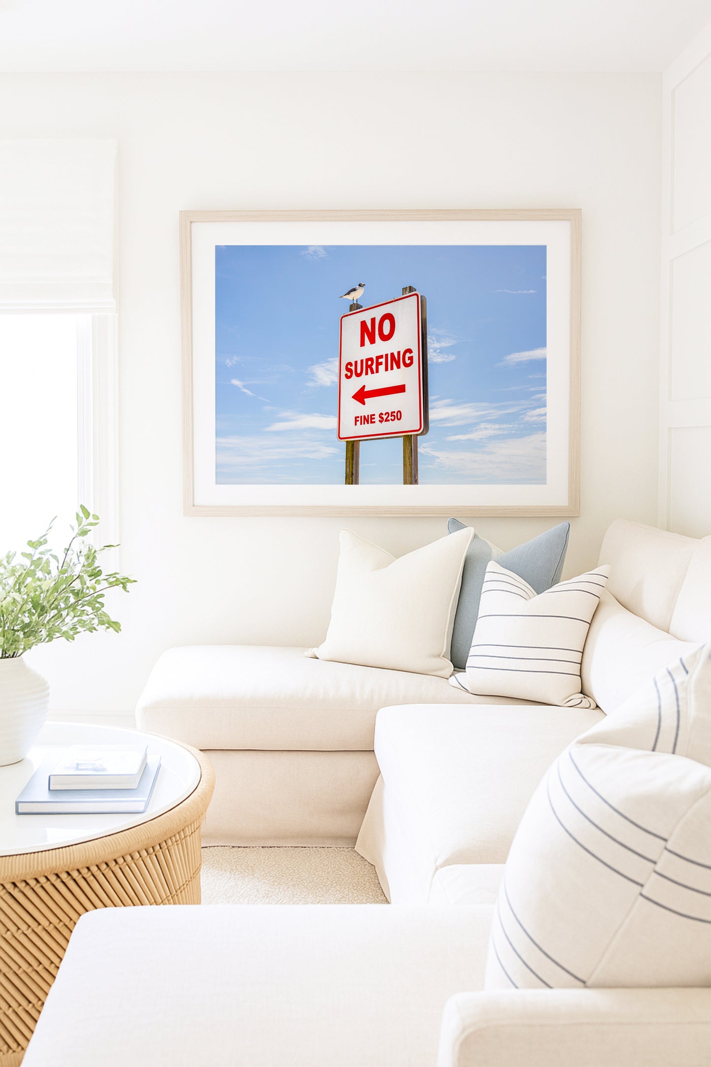 Color fine art photograph of a red and white No Surfing Fine $250 sign at Wrightsville Beach in Wilmington, North Carolina — a seagull perched on top of the sign against a blue sky