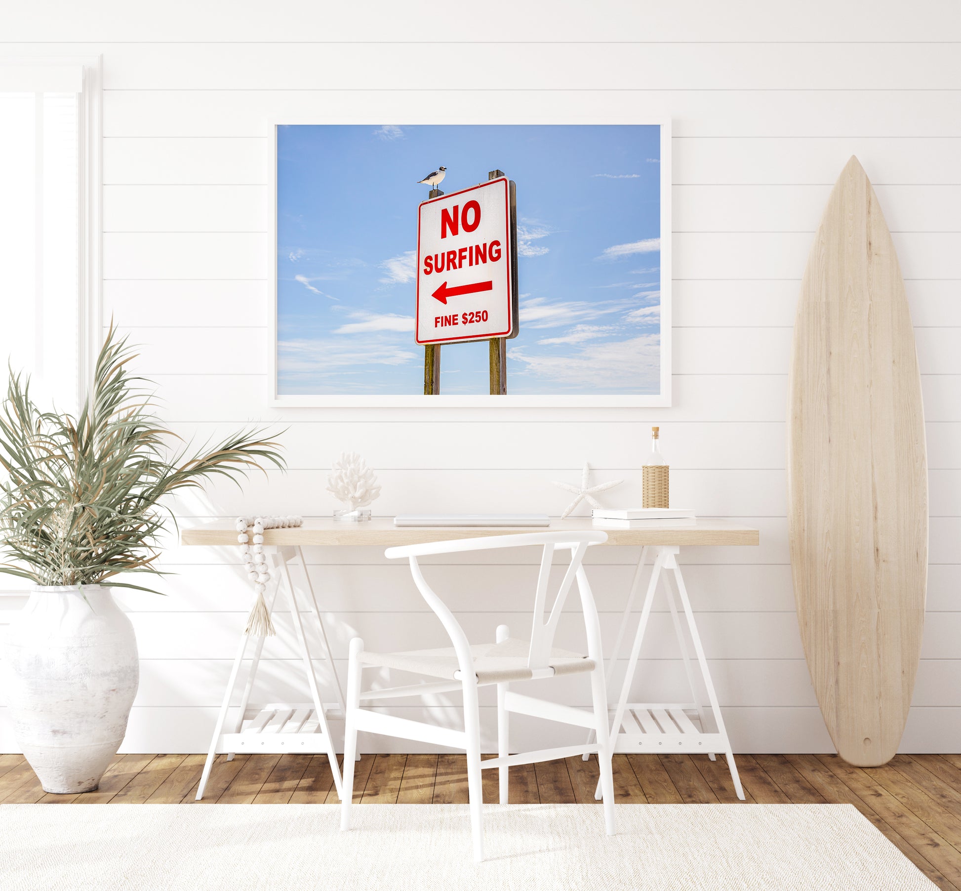 Color fine art photograph of a red and white No Surfing Fine $250 sign at Wrightsville Beach in Wilmington, North Carolina — a seagull perched on top of the sign against a blue sky
