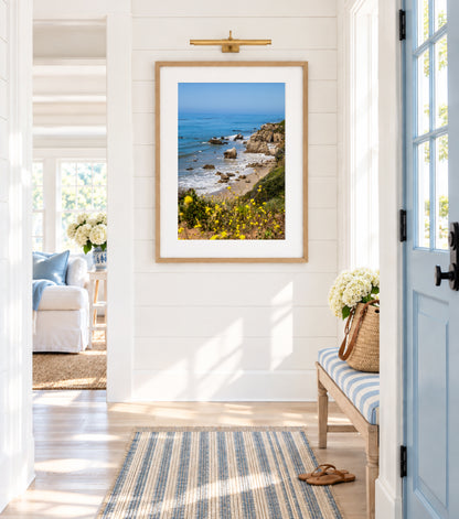 Vertical California coastal photo of El Matador State Beach with yellow wildflowers, rocks, and blue ocean