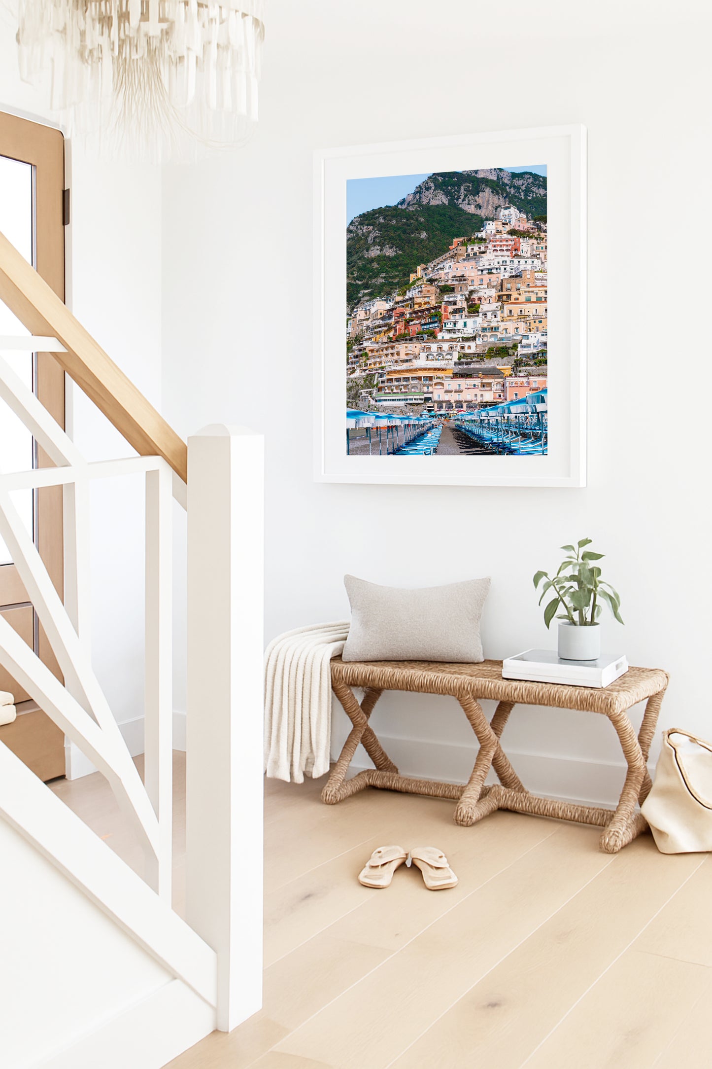 Rows of blue and white beach umbrellas and loungers on Spiaggia Grande with the colorful hillside buildings of Positano stacked up the cliffside, Amalfi Coast, Italy